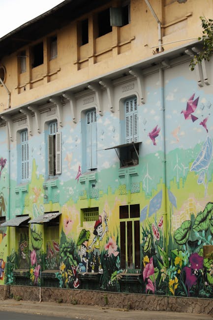 Hausfassade mit großflächigem Wandgemälde und pastellfarbenen Fensterläden auf Sardinien
