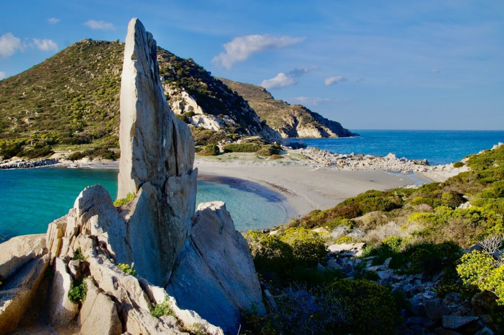 Markanter Felsen am Strand mit türkisfarbenem Wasser in Sardinien