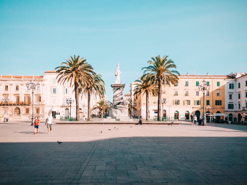 Piazza ampia con statua e palme nel centro di Sassari, Sardegna