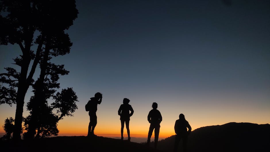 Silhouetten von Wanderern am Gipfelrand vor Sonnenuntergang in Sardinien