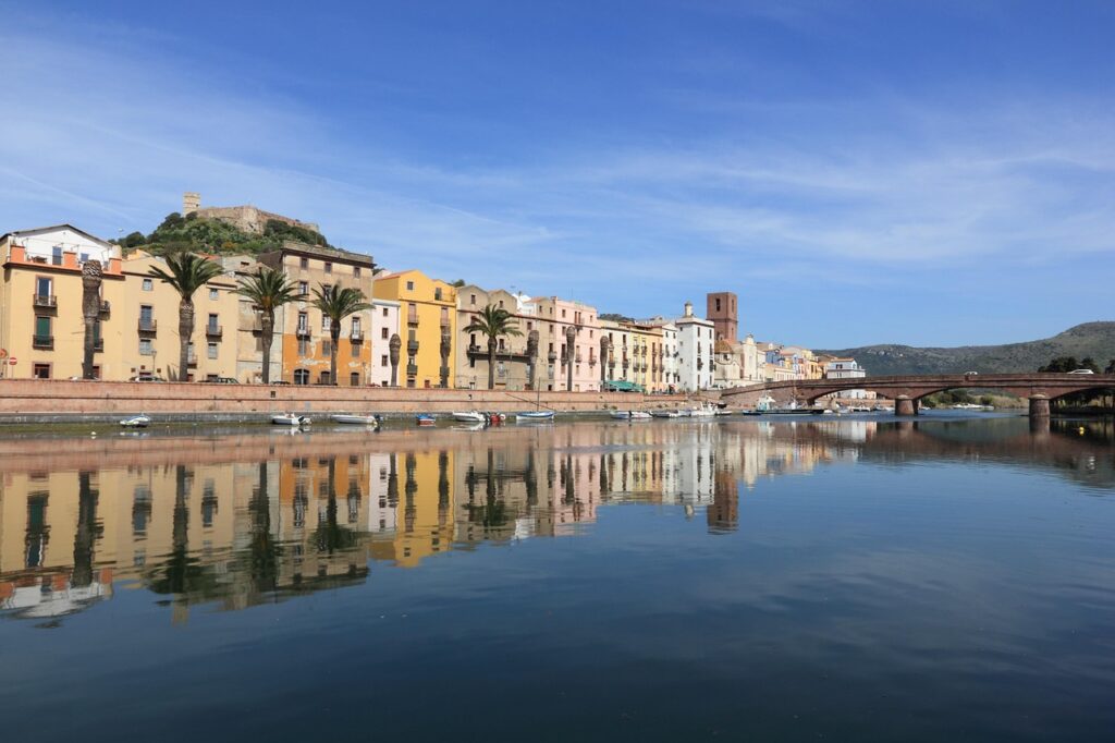 Maisons colorées reflétées dans l'eau d'un fleuve calme en Sardaigne