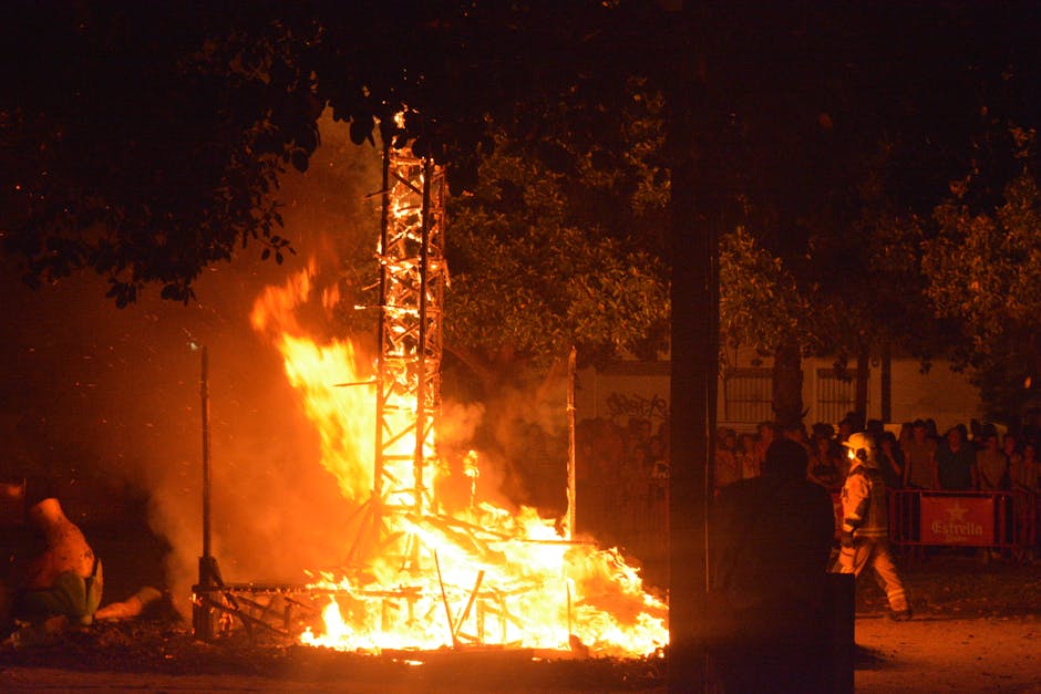 Feu de grande structure en flammes, spectateurs et pompier en Sardaigne