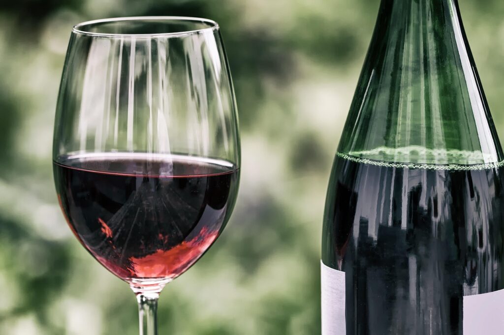 Verre de vin rouge et bouteille, flou vert en arrière-plan Sardaigne