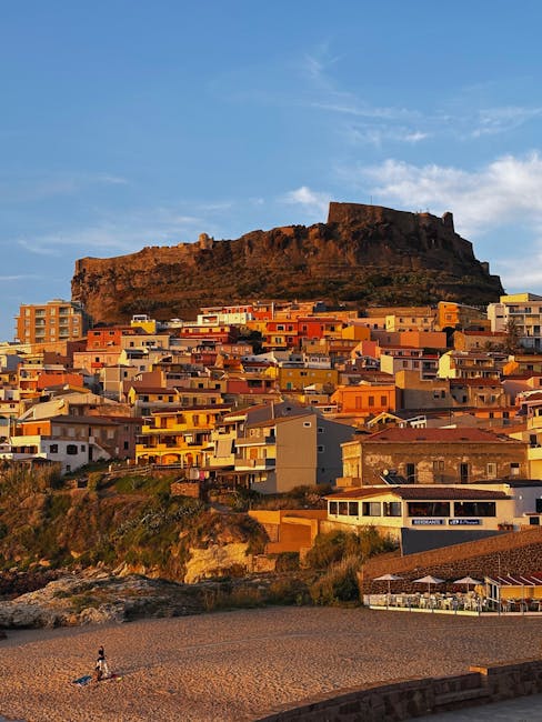 Ville côtière aux maisons colorées et château sur la colline au coucher, Sardaigne