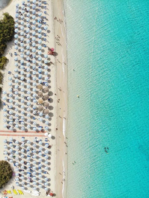 Spiaggia affollata di ombrelloni e acqua turchese in Sardegna