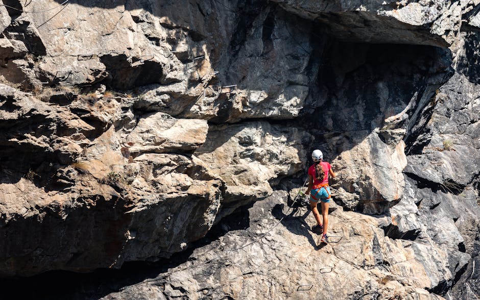 Grimpeuse équipée progressant le long d'une paroi rocheuse du Pecorile en Sardaigne