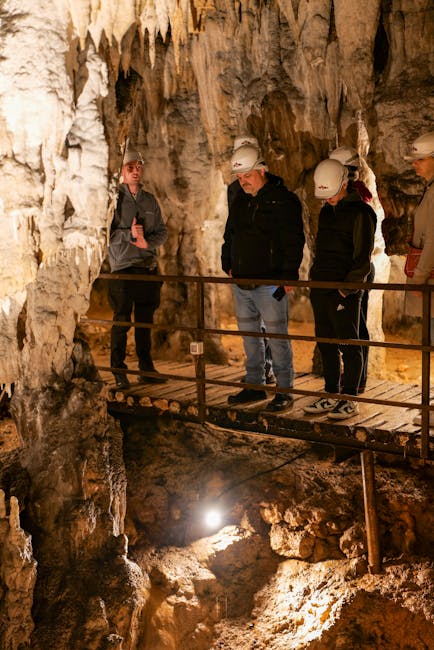 Visiteurs casqués sur passerelle en bois parmi stalactites d'une grotte en Sardaigne