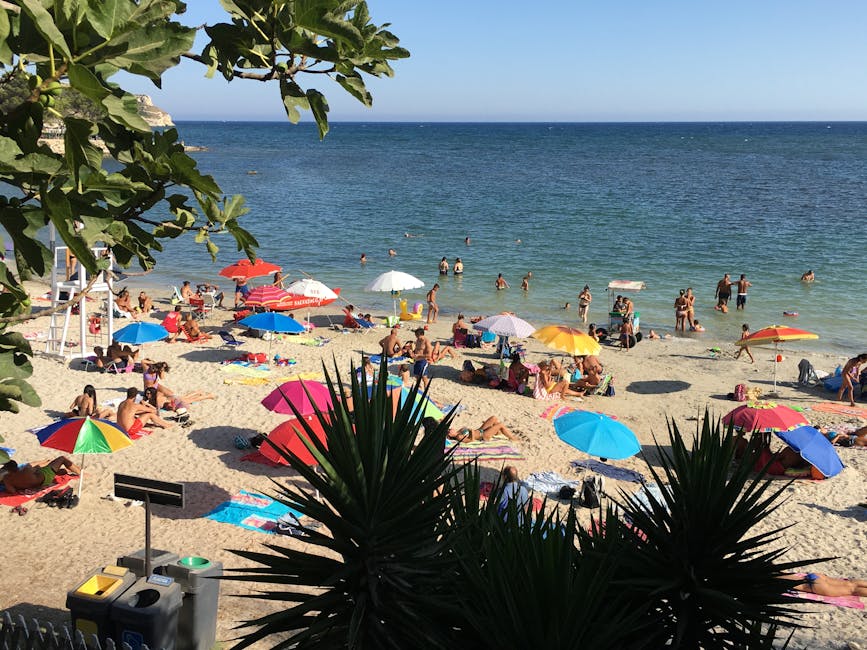 Plaża na Sardynii z kolorowymi parasolami i kąpiącymi się ludźmi