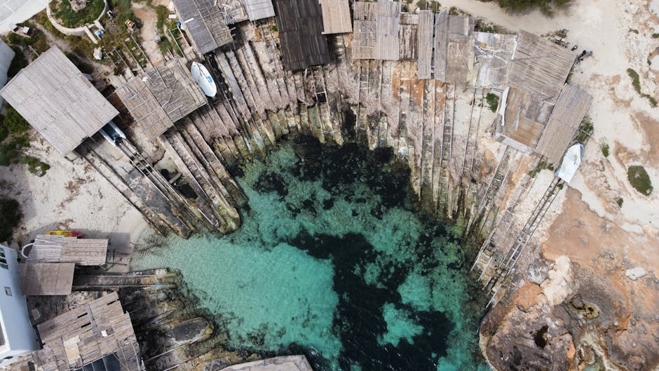 Vue aérienne de cales en bois et eau turquoise sur la côte sarde