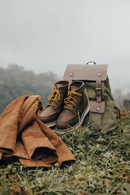 Bottes et sac à dos posés sur herbe brumeuse, prêt pour randonnée en Sardaigne