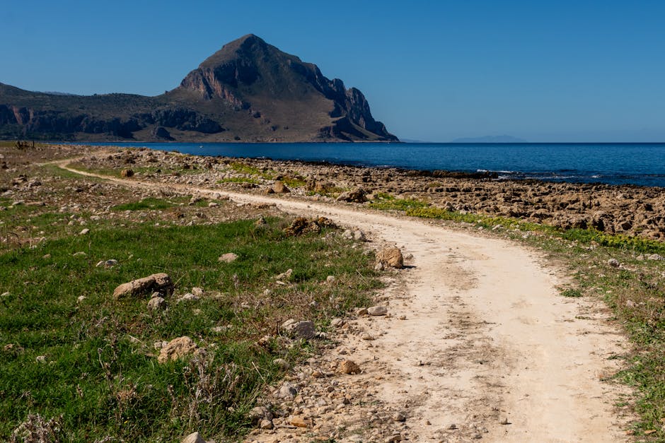 Kieseliger Küstenpfad zum markanten Bergmassiv auf Sardinien