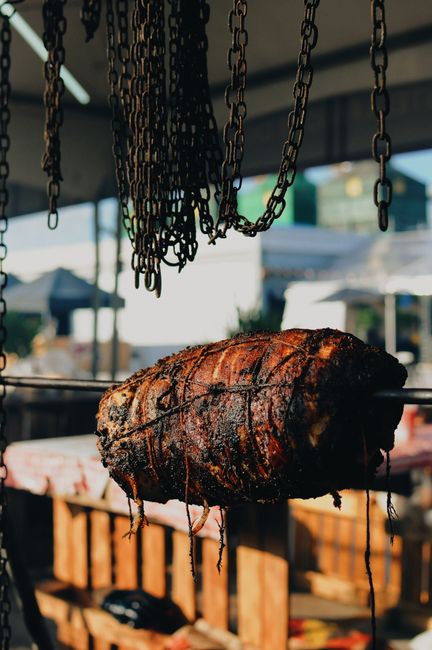 Seasoned pork roast tied and slowly rotating on open spit