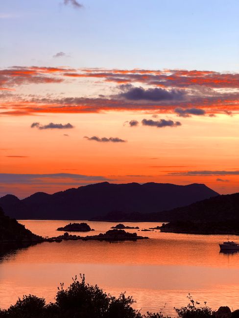 Tramonto arancione sull'arcipelago con isolotti e mare calmo in Sardegna