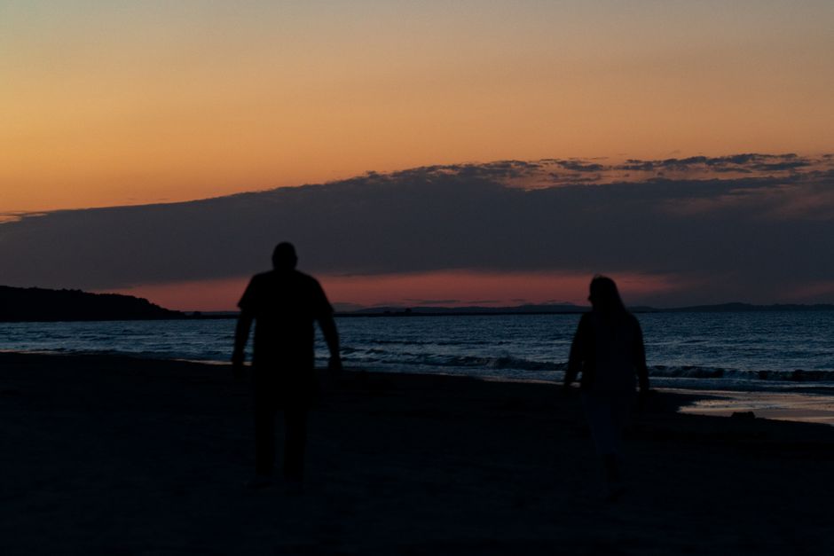 Couple walking on a Sardinian beach at sunset