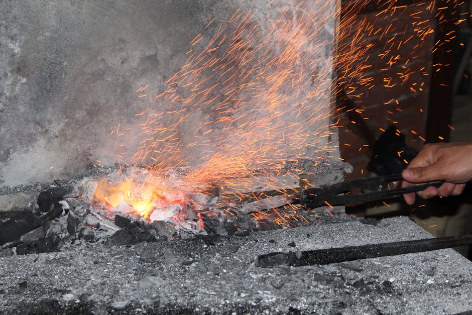 Iskry z kuźni podczas kucia rozgrzanego metalu na warsztatach w Parmie