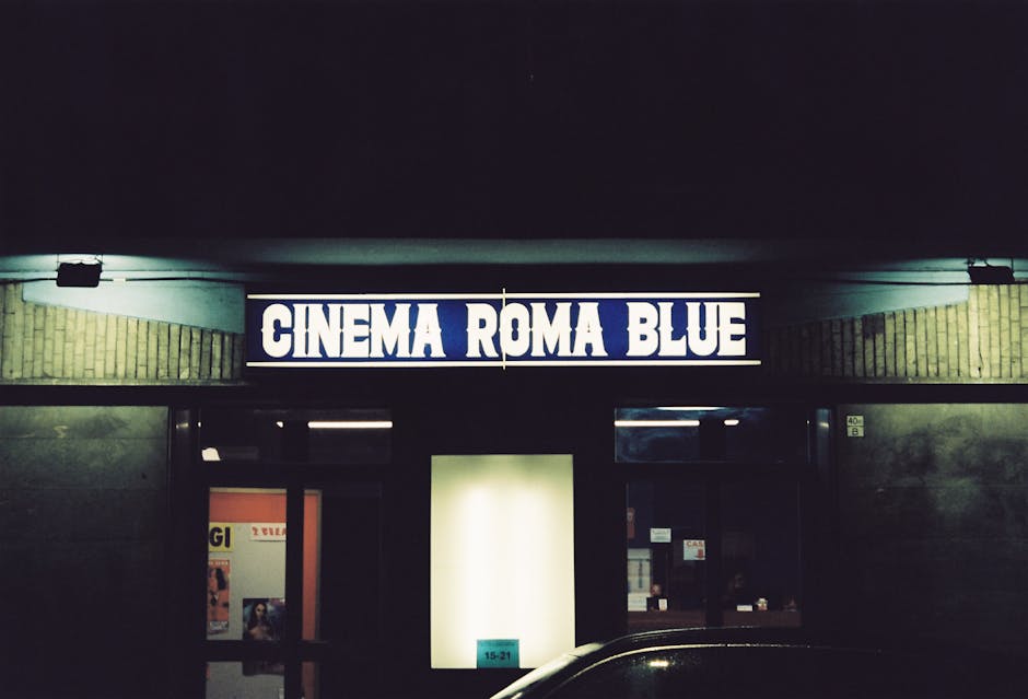 Blue-lit CINEMA ROMA BLUE marquee above a darkened cinema entrance