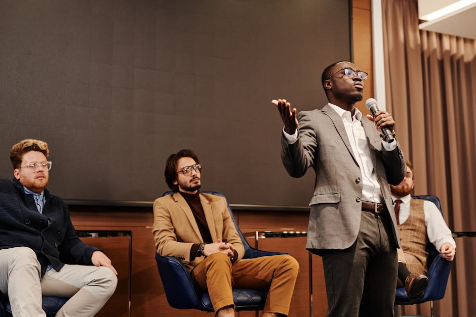 Speaker addressing audience during a Parma cultural talk with seated panelists