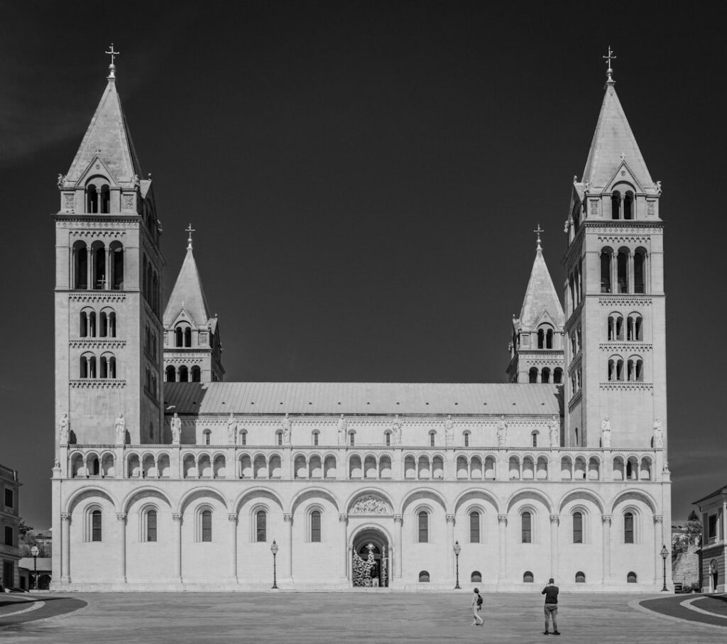 Front facade of Parma Cathedral with twin bell towers in sunlight