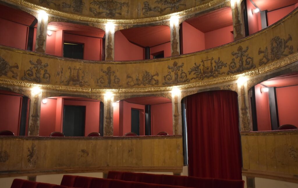 Three-tiered vintage theater boxes with red curtains in Parma