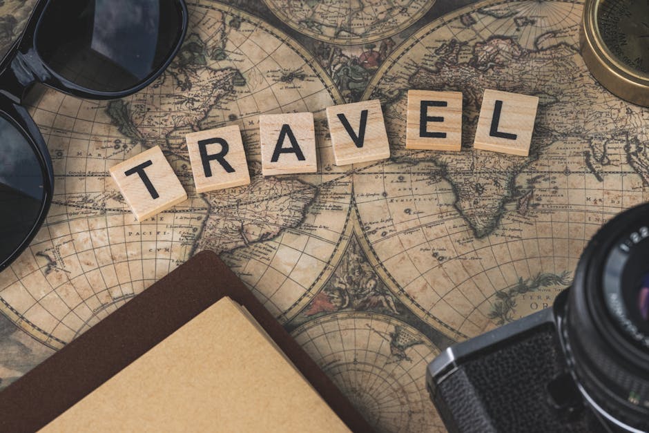 Scrabble tiles spelling TRAVEL on a vintage map with camera