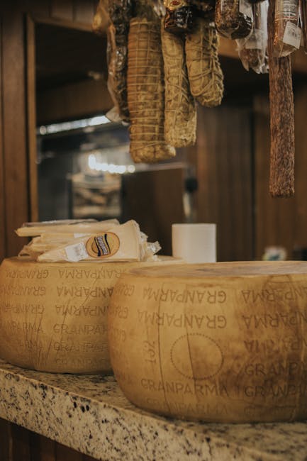 Fromages et saucissons suspendus exposés dans une boutique gourmande de Parme