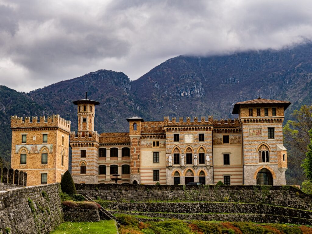 Castello neorinascimentale con torri e bastioni ai piedi delle montagne