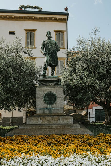 Statua monumentale circondata da fiori e ulivi a Parma