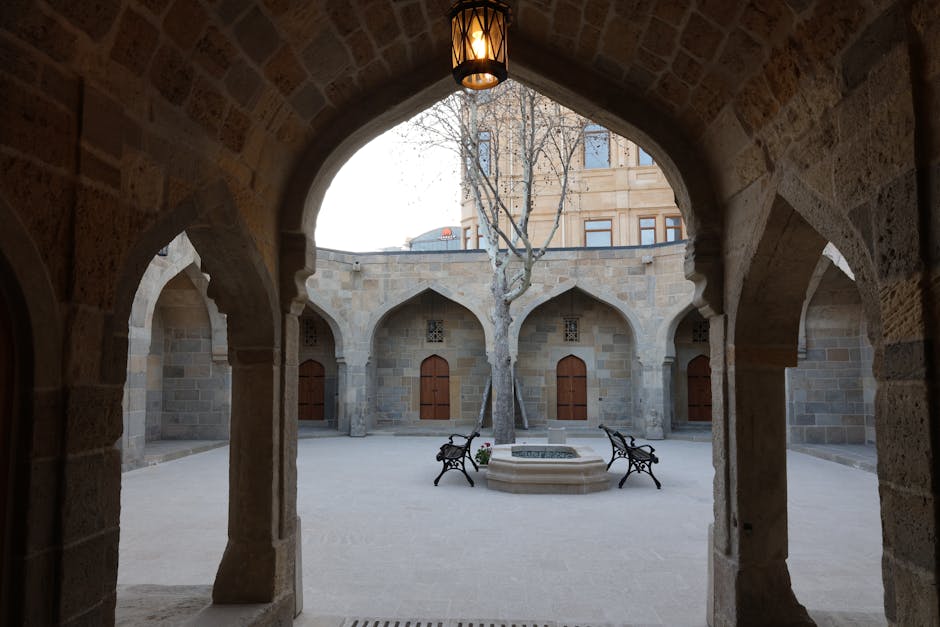 Stone courtyard framed by arched colonnade and central fountain