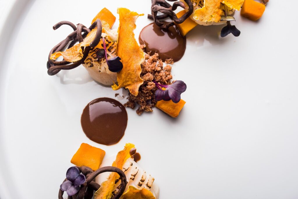 Dessert gourmet con salsa al cioccolato e decorazioni arancioni, Parma
