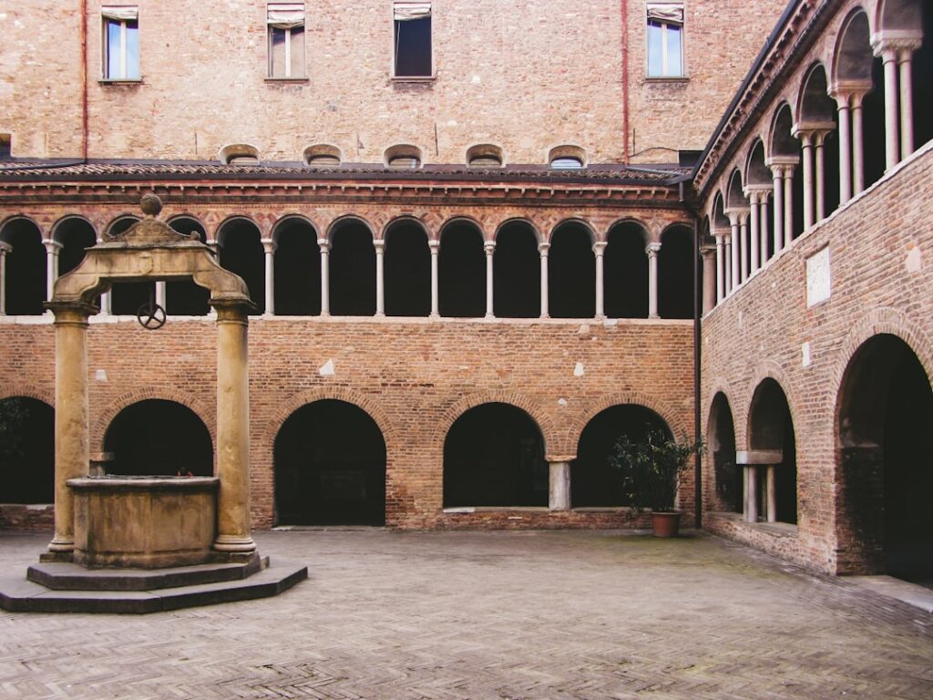 Medieval brick cloister courtyard with central well in Parma