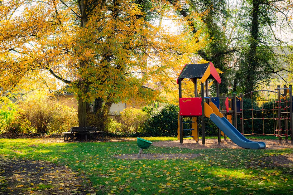 Kolorowy plac zabaw pod jesiennym drzewem w parku w Parmie