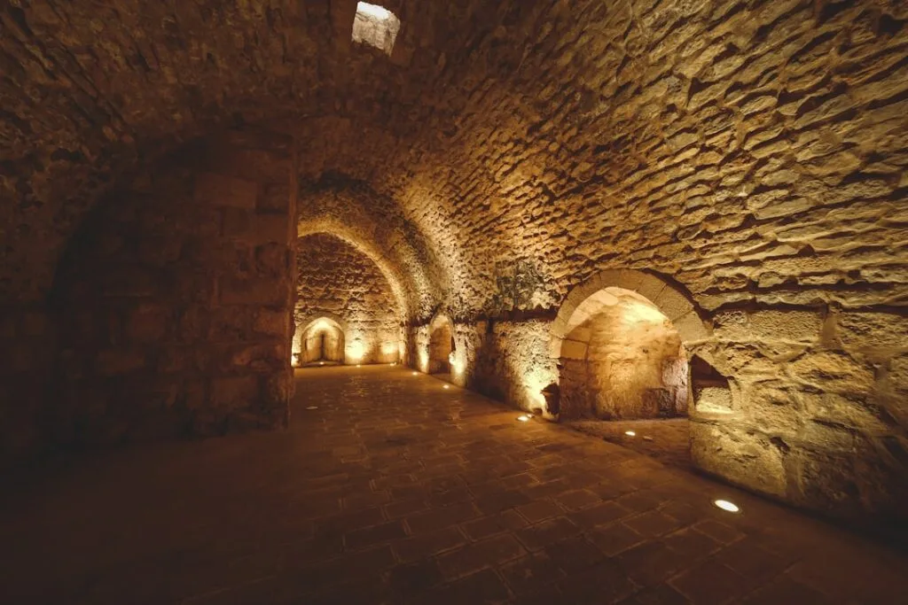 Crypte voûtée en pierre éclairée par de petits spots