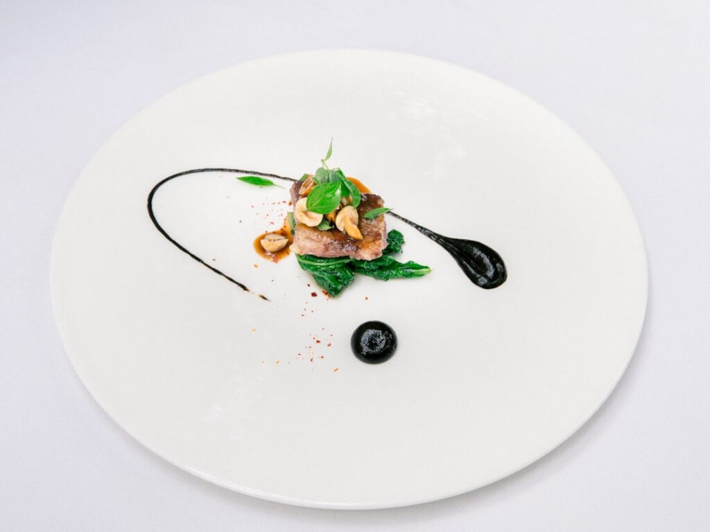 Minimalistyczne danie degustacyjne podane na białym talerzu w Parmie