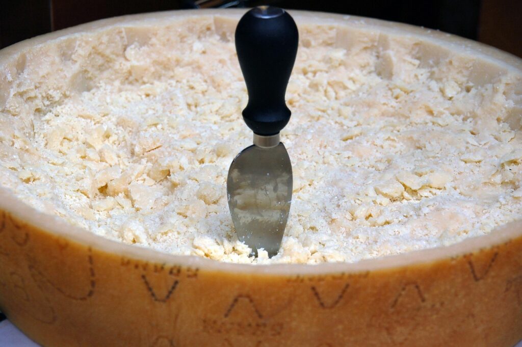 Couteau planté dans le cœur d'une meule de Parmigiano râpée