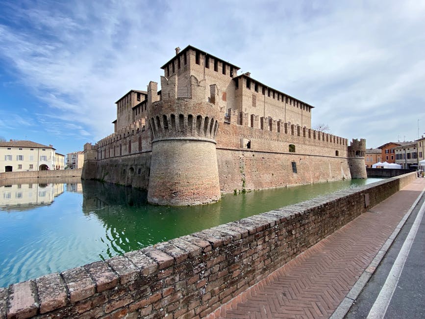 Forteresse médiévale entourée d'un fossé, reflets verts dans l'eau