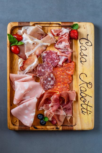 Charcuterie board with prosciutto, culatello and Parmesan in a Parma shop setting