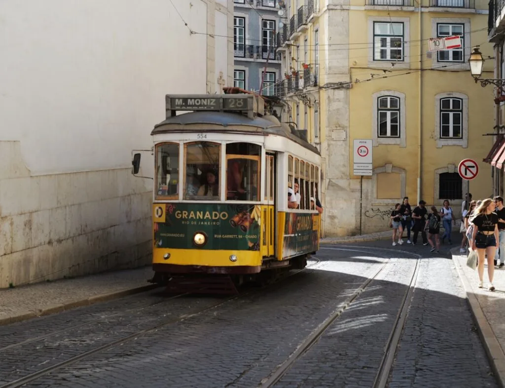 Tram jaune historique naviguant dans une rue pavée de Lisbonne