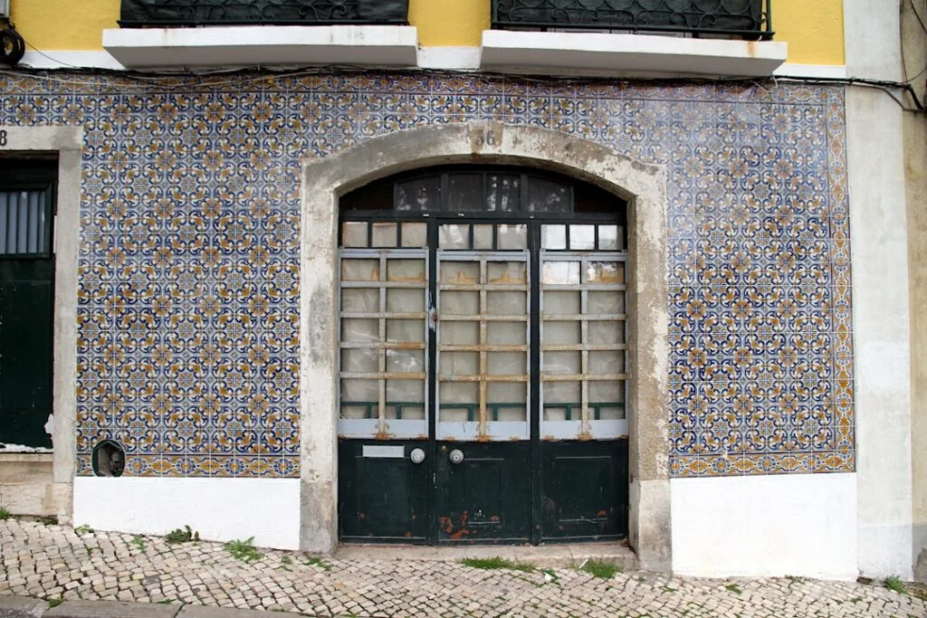 Bunte Azulejo-Fassade und dunkle Holztür an einem Lissaboner Gebäude