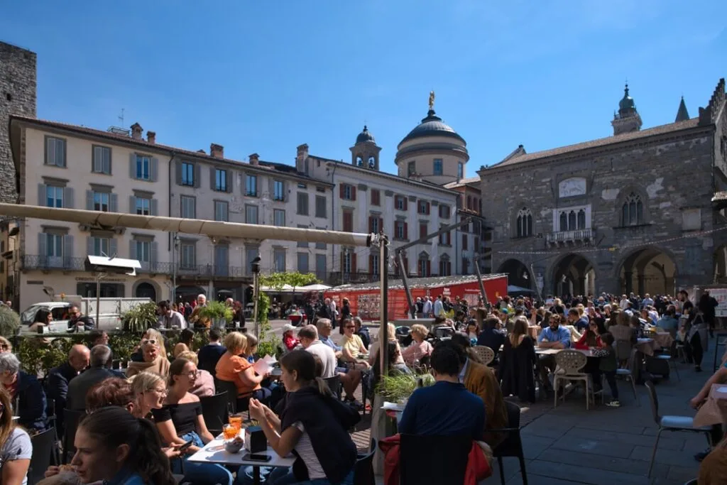 Außenterrasse eines Cafés in Bergamo mit Gästen und moderner Atmosphäre
