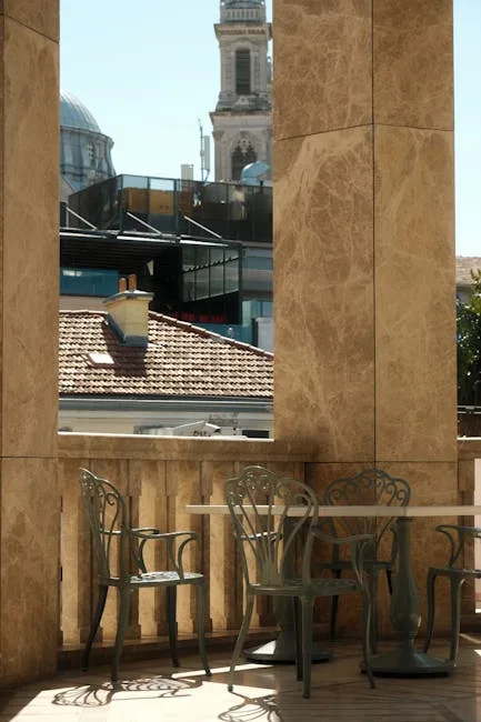 Balcon en pierre à Bergame avec tables métalliques et clocher en arrière-plan