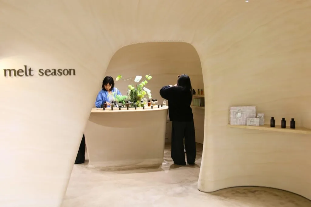Intérieur organique d'une boutique design à Bergame, clientes testant parfums