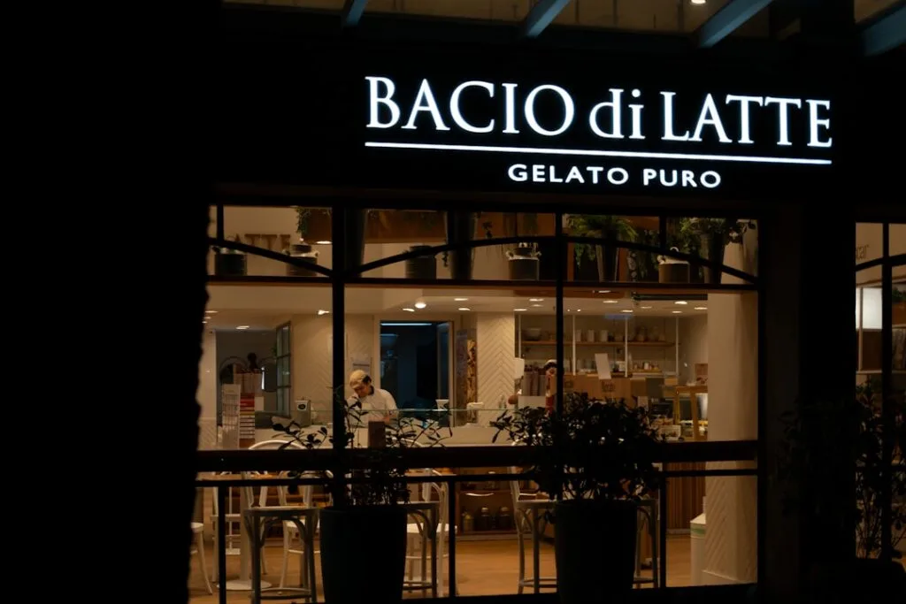 Façade éclairée du glacier Bacio di Latte à Bergame, vitrine visible
