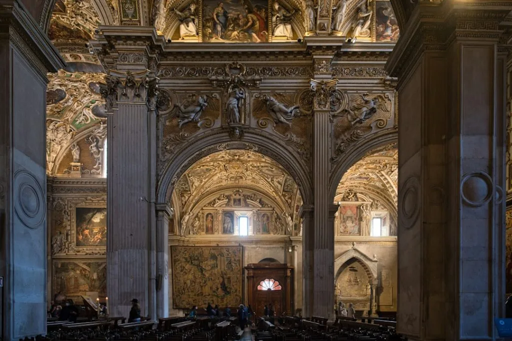 Nef et arches ornées, visiteurs admirant les fresques de la basilique à Bergame