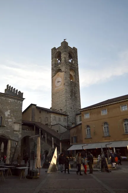 Tour médiévale avec cadran d'horloge sur une place animée, Bergame
