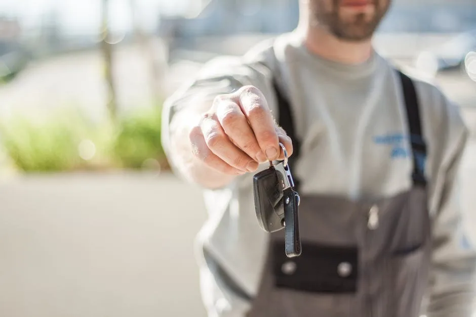 Main tendue présentant des clés de voiture lors d'une remise