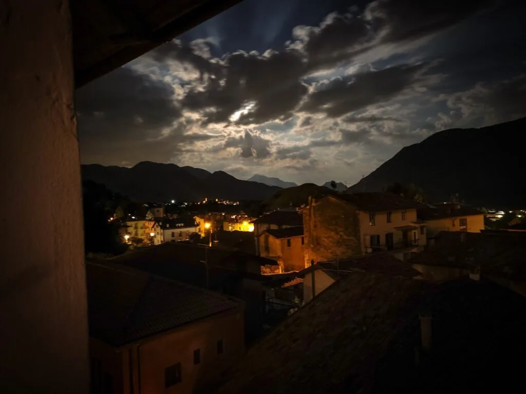 Nuit et nuages éclairés au-dessus des toits et collines de Bergame