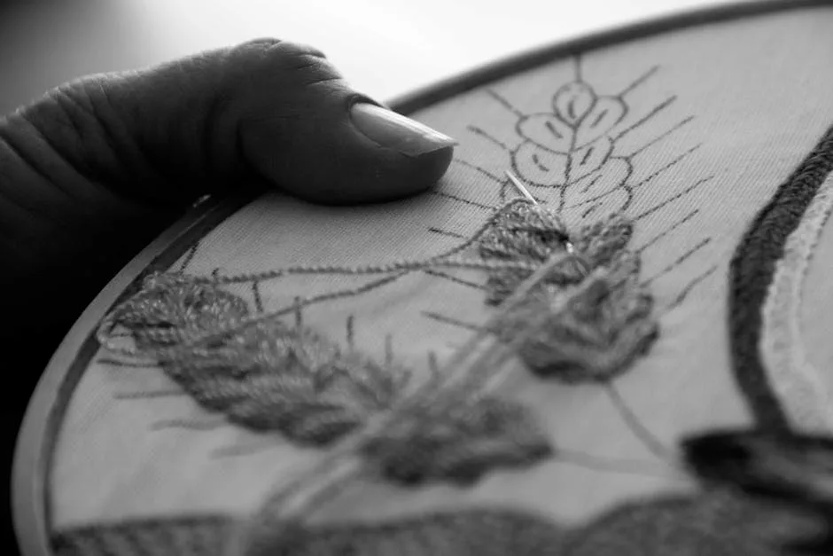 Main brodant un motif fin sur tambour, artisanat à Bergame
