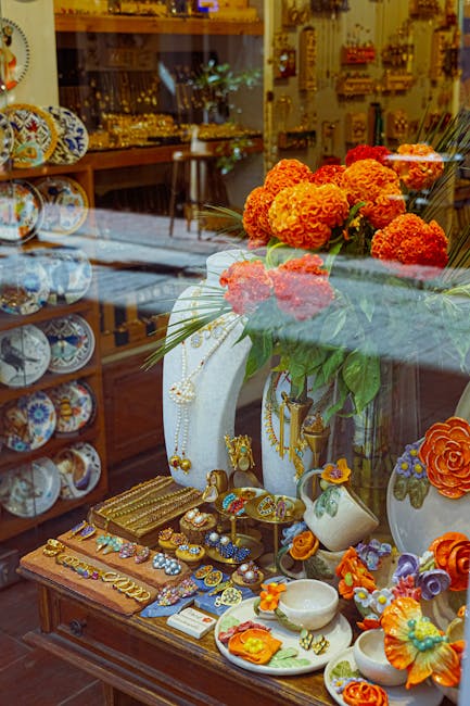 Vitrine d'artisanat à Bergame avec céramiques, bijoux et fleurs orange