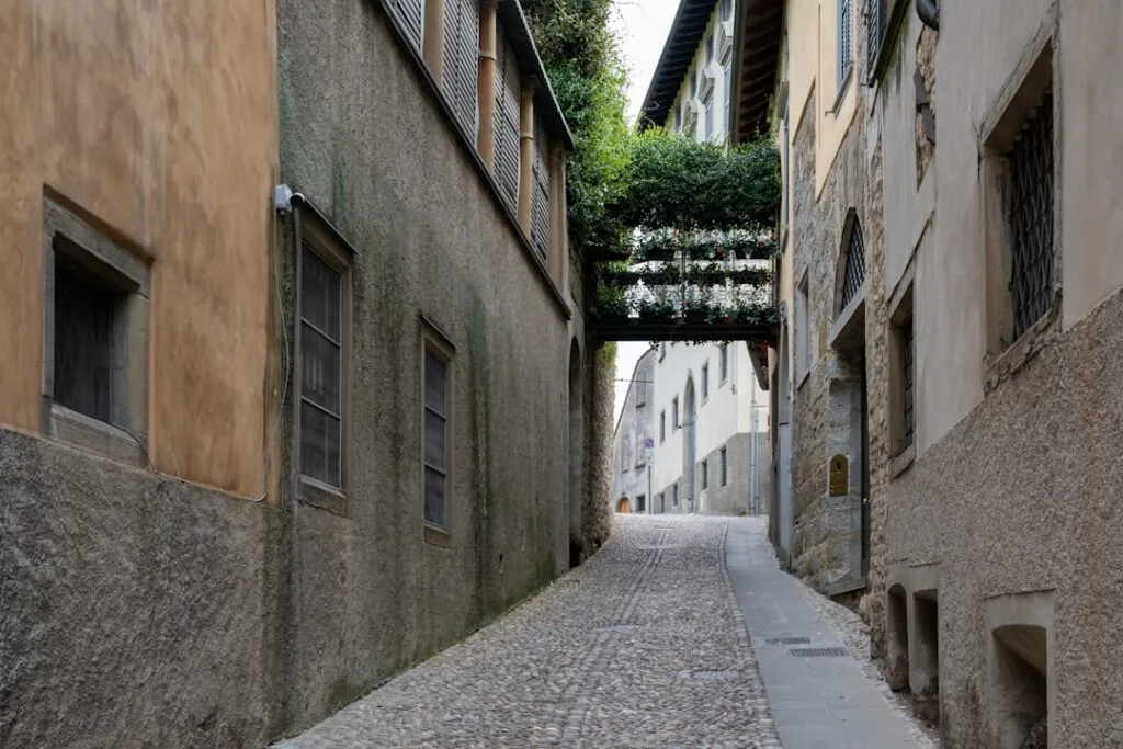 Ruelle pavée étroite à Bergame bordée de façades anciennes et balcons