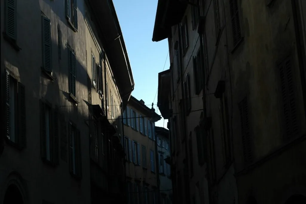 Ruelle étroite et ombragée bordée de maisons à Bergame Alta.